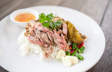 Pork leg rice on a wooden table, soft focus image.