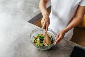 caucasian woman preparing chiken breasts , healthy meal in her rustic eco open kitchen