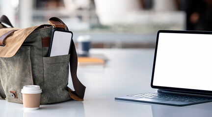Mockup blank screen tablet on the table and blank screen smartphone in shoulder bag. Working online...