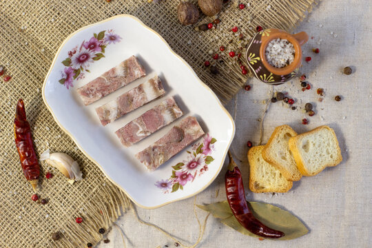 Homemade brawn headcheese meat product saltison on rough linen cloth with sea salt and spices