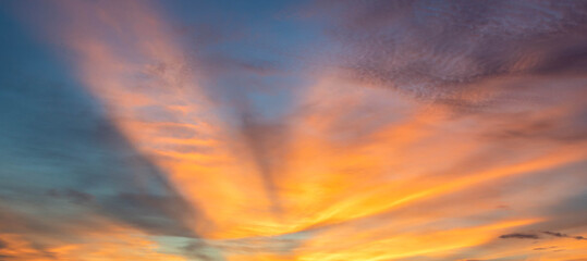 Dramatic sunset sky with orange colored clouds..