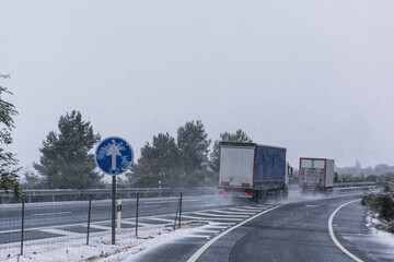 Two trucks driving with little safety distance on the highway on a day of adverse weather due to...
