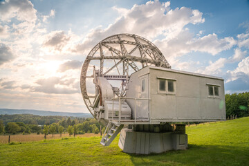 Satellite dish in a summer landscape, radiotelescope for deep space research. Ondrejov observatory, Czech republic.