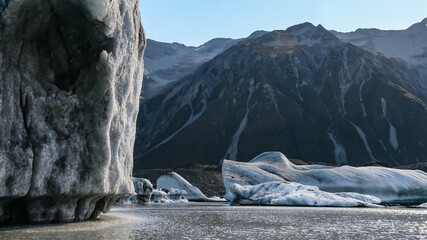Landscape view of Icebergs in the glacial lake at the foot of the Tasman glacier, Aoraki National Park, New Zealand. The glacier is in rapid retreat and tourist cruises are now restricted.