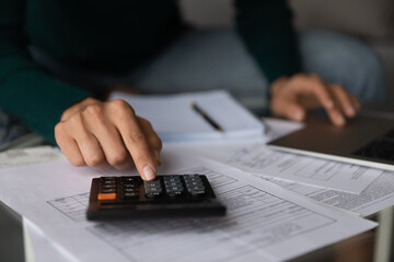 Crop close up of woman busy taking care of family financial paperwork, calculate expenses...