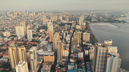 Manila pier town cityscape at ocean bay aerial. Architecture attraction and modern buildings. Amazing streets at roads with green trees. Cinematic Philippines metropolis scenery at summer day