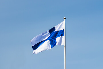 Finnish national flag on the wind against the blue sky