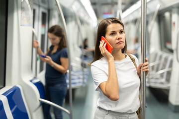 Woman talking on a cell phone in a subway car. High quality photo