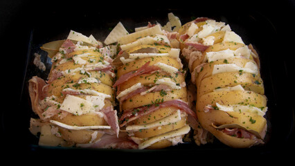 Patatas de tamaño grande con cortes para insertar queso y jamón o beicon.