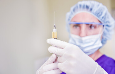 Platelet-Rich plasma preparation. Syringe with plasma in hands