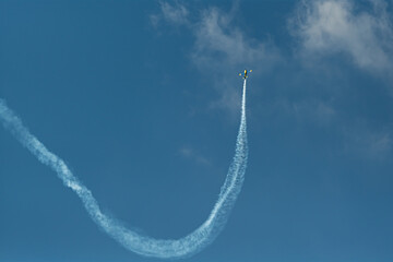 The aerobatic plane with smoke track in the sky