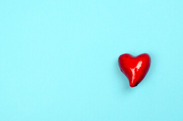 Small red heart on a blue background. Health care concept. World heart day