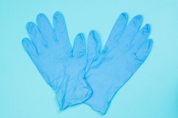Fototapeta premium Blue medical gloves on a light blue background