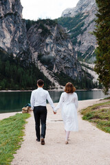 Couple walking near famous lake Lago Di Braies in Italy