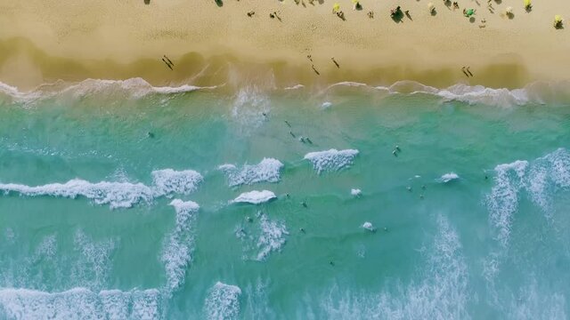 Aerial shot of waves breaking on the shore. Colourful beach summer. 4K.
