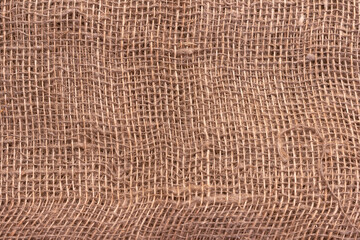 The texture of an uneven crumpled, roughly woven burlap.