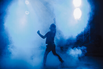 Fototapeta na wymiar boy dancing in blue smoke