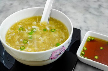 Hot Chicken Clear Soup in a bowl along with spicy chilli sauce to accompany