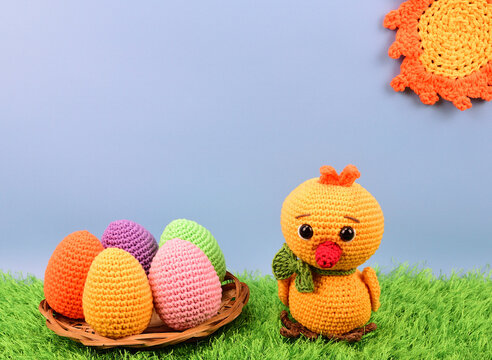 Knitted Yellow Chicken Next To A Plate Of Colorful Easter Eggs