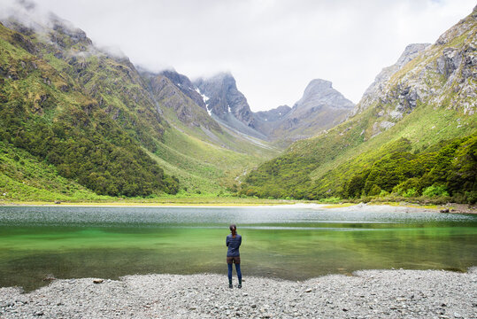 Person stand in front of Emily Peak in Lake Mackenzie at the famous Routeburn Track in Summer, Fjordland National Park, Southland, New Zealand