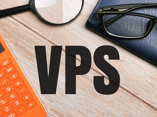 Top view marker eye glasses,calculator,book and magnifying glass with text VPS written on wooden background.Business concept.