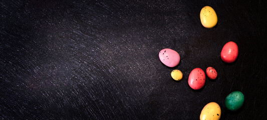 Fototapeta na wymiar Easter background, colorful eggs on a dark background