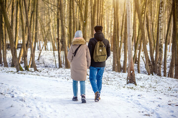 
A guy and a girl walking in winter Park
