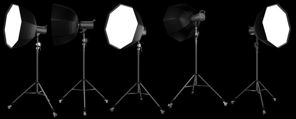 Photo studio lighting stands with flash and softbox isolated on the black.