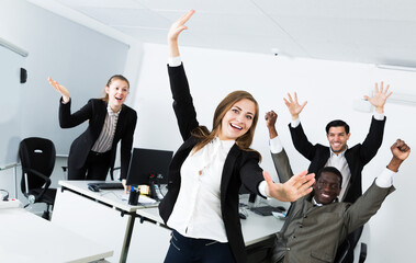 Satisfied multinational business team expressing satisfaction with teamwork in meeting room,...