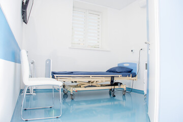 Modern empty and clean hospital room with medical equipment and TV