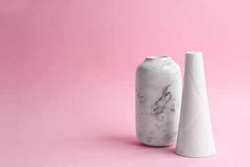 Stylish empty ceramic vases on pink background. Space for text