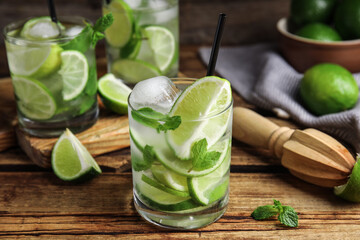 Delicious mojito and ingredients on wooden table