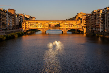 view of the famous Ponte Vecchio bridge over the Arno river before sunset.