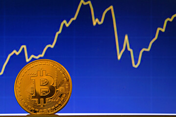 Bitcoin coin on the background of the stock chart. Virtual cryptocurrency concept.