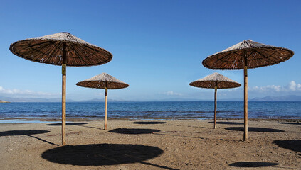 sun straw umbrellas on a sandy beach in Greece