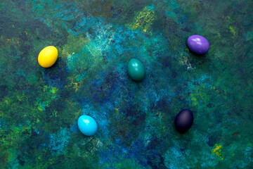 Color easter eggs on blue oil paint mixed background. Easter hipster concept.