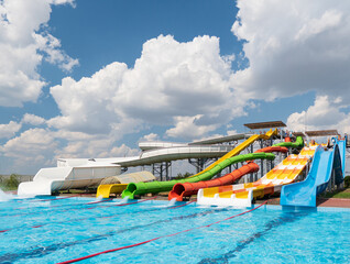 Water park, bright multi-colored slides with a pool. A water park without people on a summer day...