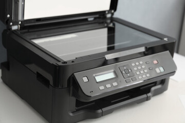Open modern printer with control panel on white table, closeup