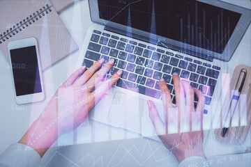 Double exposure of woman hands working on computer and forex graph hologram drawing. Top View. Financial analysis concept.