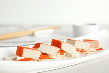 Fresh delicious crab sticks served on white plate, closeup