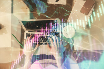 Double exposure of woman hands working on computer and forex chart hologram drawing. Top View....