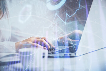 Double exposure of woman hands working on computer and forex graph hologram drawing. Financial analysis concept.