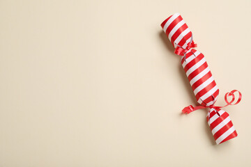 Christmas cracker on beige background, top view. Space for text