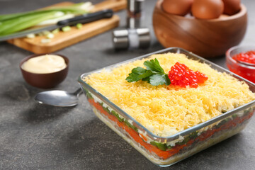 Traditional russian salad Mimosa served on grey table
