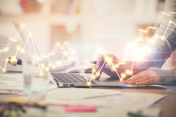 Double exposure of woman hands typing on computer and forex chart hologram drawing. Stock market invest concept.