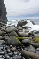Fototapeta na wymiar Big waves crashes into rock at stoney beach on Madeira Island