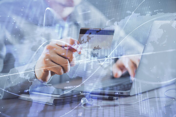 Double exposure of man hands holding a credit card and Forex graph drawing. Stock trading and digital fintech in Internet E-commerce concept.