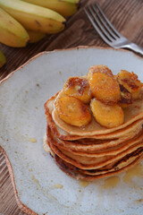 Delicious pancakes with banana and on wooden table. Breakfast time 