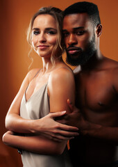 Naklejka premium Young pretty couple diverse races together posing sensitive on brown background, lifestyle people concept