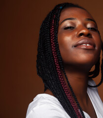 pretty young african american woman with braids posing cheerful gesturing on brown background, lifestyle people concept